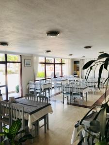 a dining room with tables and chairs and windows at Albayrak Hotel in Çeşme