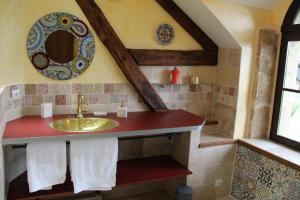 un bagno con lavandino e specchio di Le Moulin Chevillon a Cercy-la-Tour Altre 11 foto