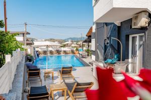 Un balcón con sillas y una piscina. en Sunshine Hotel, en Ksamil