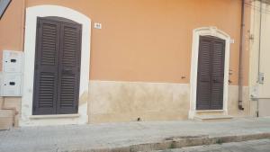 two black doors on the side of a building at Casa Salento in Alezio