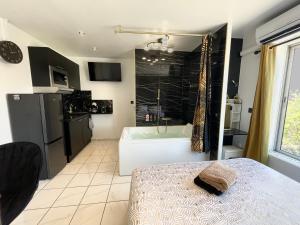 une salle de bain avec baignoire et un lit dans une chambre dans l'établissement Luxury Beach Room, à Frontignan
