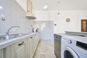 a kitchen with a sink and a washing machine at La Lenzerina in Scarlino