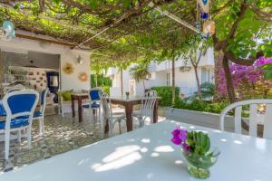 a patio with tables and chairs and a kitchen at Mon Ilıca Otel in Çeşme