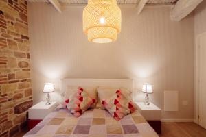 a bedroom with a bed with two night stands and two lamps at Winding Village Bilo in Trevi