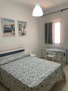 a bedroom with a bed and a table and a window at Estocolmo Lovely in Gran Tarajal