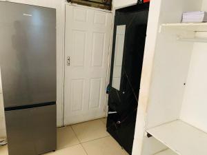 a closet with a white door and a refrigerator at Kasi Roots Living in Soweto