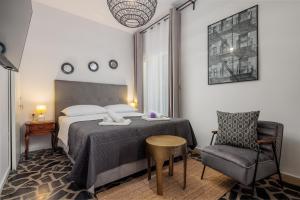 a hotel room with a bed and a chair at Villa Mare's in Primošten