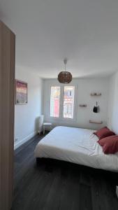 Un dormitorio blanco con una cama grande y una ventana. en Appartement la gare, en Tarbes