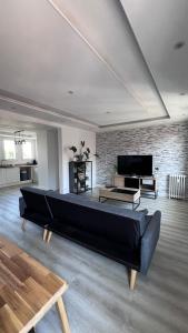sala de estar con sofá grande y TV en Appartement la gare, en Tarbes