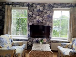a living room with two chairs and a flat screen tv at Matrix Garden Apartments in Tallinn
