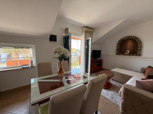 a living room with a glass table and chairs at Grand Apartments Scepanovic in Tivat