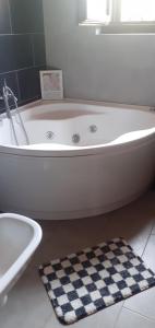 a white bath tub in a bathroom with a checkered rug at Casa Pratolungo in Velletri +14 photos