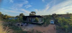 a small house with a car parked next to it at Chalé Container Terracota in Santana do Riacho
