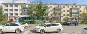 three white cars parked in a parking lot in front of a building at Cozy Central City Apartment in Ulaanbaatar