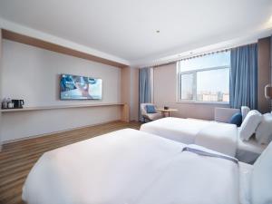 Un pat sau paturi într-o cameră la Elong Hotel City Hall Branch