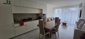 a kitchen with a wooden table and chairs in it at Soldouro Aveiro Station in Aveiro
