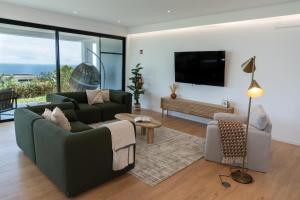 a living room with a couch and a tv at Auréa House - Luxury Ocean View in Feteiras