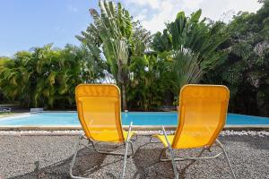 サン・フランソワにあるVilla 5 étoiles Piscine à débordement accès PMRの黄色い椅子2脚(スイミングプールの隣に座る) +32枚の写真