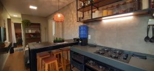 a kitchen with a stove and a counter top at Chalé Container Terracota in Santana do Riacho