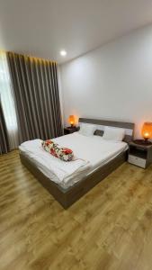 Un dormitorio con una cama con sábanas y almohadas blancas. en Căn Hộ 2 PN Ocean-vista, en Ấp Phú Tịnh (2)