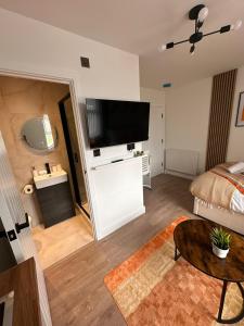 a living room with a bed and a flat screen tv at R4 - Luxury fully Self-Contained Studio with Private Bathroom and Kitchen in Halesowen