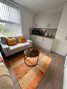a living room with a couch and a table at R4 - Luxury fully Self-Contained Studio with Private Bathroom and Kitchen in Halesowen