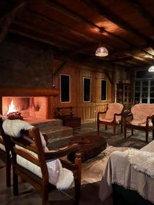 a large living room with a fireplace and chairs at Divina Reserva- Cabana Alecrim in Bom Retiro