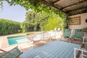 a patio with chairs and a swimming pool at Villaflair - Porto Ercole Pool Villa in Porto Ercole