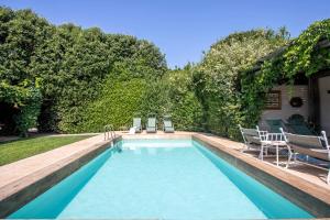 a swimming pool with two chairs and a table at Villaflair - Porto Ercole Pool Villa in Porto Ercole