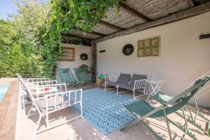 a group of chairs and tables on a patio at Villaflair - Porto Ercole Pool Villa in Porto Ercole