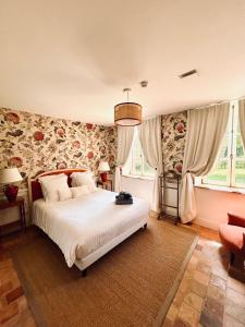 a bedroom with a large bed with floral wallpaper at Manoir de Daubeuf in Daubeuf-Serville