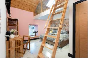 a room with a ladder leading to a bedroom at La Casita in Breage