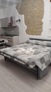Cama grande en habitación con pared en My Mini Maison, en Castel dʼAiano