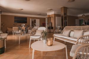 a living room with a couch and chairs and tables at Hotel MioMio in Tignale