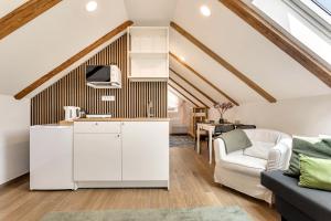 a kitchen with white cabinets and a living room at Mirola homes - rent in nature in Zagorje ob Savi