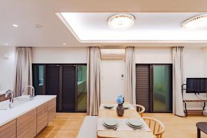 Una cocina con una mesa con sillas y un fregadero. en 花音Kanon, en Osaka