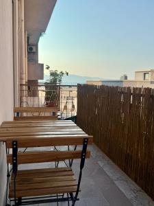 a group of wooden benches sitting on a balcony at Appartamento San Marco in Reggio Calabria