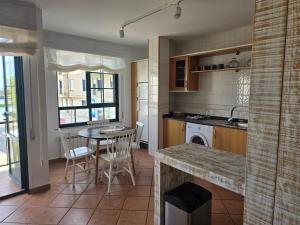 a kitchen with a table and a dining room at Winahost Salvora en Primera Línea de Mar in Ribeira