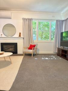 a living room with a fireplace and a television at Bendigo Bliss - Cheerful & Spacious Home in Bendigo in Kangaroo Flat