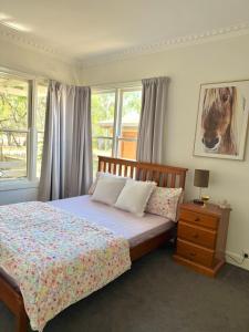 a bedroom with a bed with a horse picture on the wall at Bendigo Bliss - Cheerful & Spacious Home in Bendigo in Kangaroo Flat