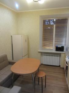 a living room with a table and a refrigerator at Apartment Lenina 9/11 in Ufa