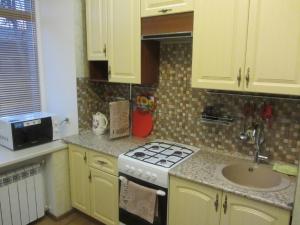 a kitchen with a stove and a sink at Apartment Lenina 9/11 in Ufa