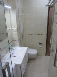 a bathroom with a white toilet and a sink at Apartment Lenina 9/11 in Ufa