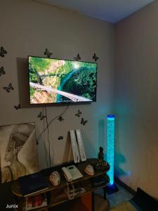 a television on a wall above a desk with a keyboard at Secure 1 bedroom + lounge & 24hr cafeteria service in Nairobi