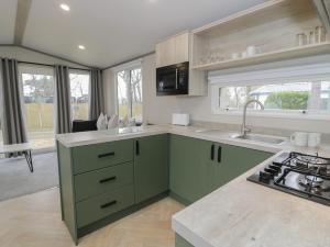 ルシンにあるWoodlands Gold WO06のキッチン(緑のキャビネット、シンク付) +9枚の写真