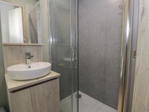 ルシンにあるWoodlands Gold WO06の洗面台とガラスのシャワーを備えたバスルーム