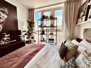 a bedroom with a large bed with a large window at Luxury Nest in the City Glow in Woolwich