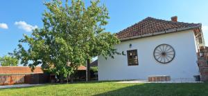 a white house with a window and a tree at Kelepelő Porta in Poroszló