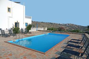 a swimming pool with chairs next to a building at Aeriko Hotel Apartments in Arvanitochori