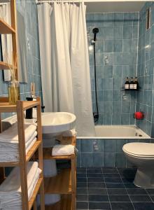 a bathroom with a tub and a sink and a toilet at Apartamento Bellreguard Playa in Playa de Miramar